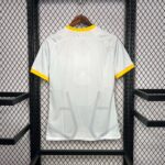 Light gray geometric-patterned shirt on a wooden hanger with yellow collar and sleeve trim, hung on a metal rack.
