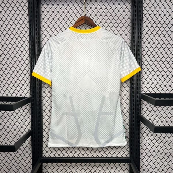 Light gray geometric-patterned shirt on a wooden hanger with yellow collar and sleeve trim, hung on a metal rack.