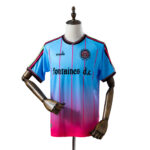 5f393dc7 | UAE SPORT STORE Blue to pink gradient soccer jersey with vertical pink stripes on a mannequin, featuring 'fontaines d.c.' sponsor text and club crest on the chest.