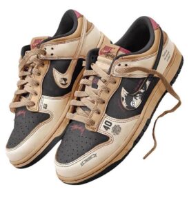 Pair of tan and black Nike sneakers with beige laces and a chunky sole, featuring graphic patches and multiple logos on the panels.