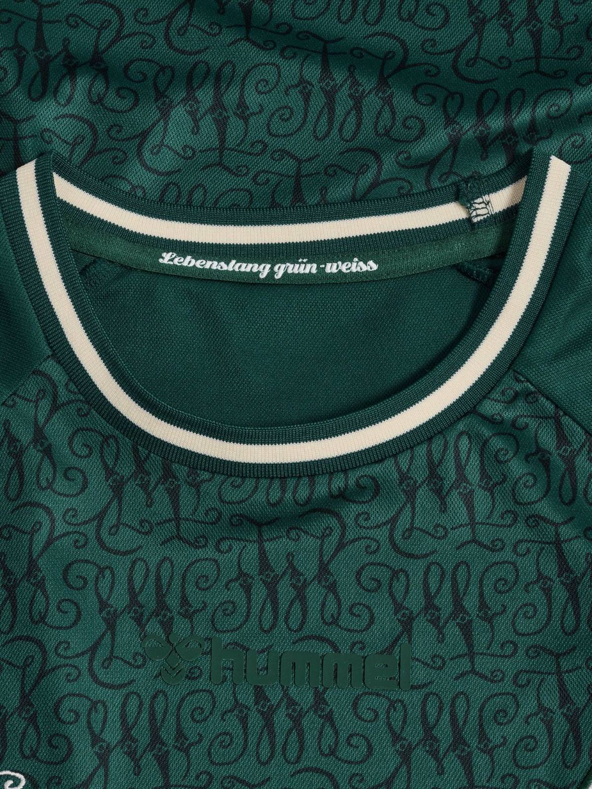5lcdDS7McyCGx5o | UAE SPORT STORE Close-up of a green sports jersey collar with a white stripe; label reads 'Lebenslang grün-weiß' and the hummel logo is embossed nearby.