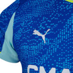 Close-up of a blue sports jersey with a white Puma logo and a pixelated light-blue pattern across the chest area.