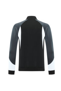 Back view of a black athletic jacket with gray sleeves and white cuff accents.