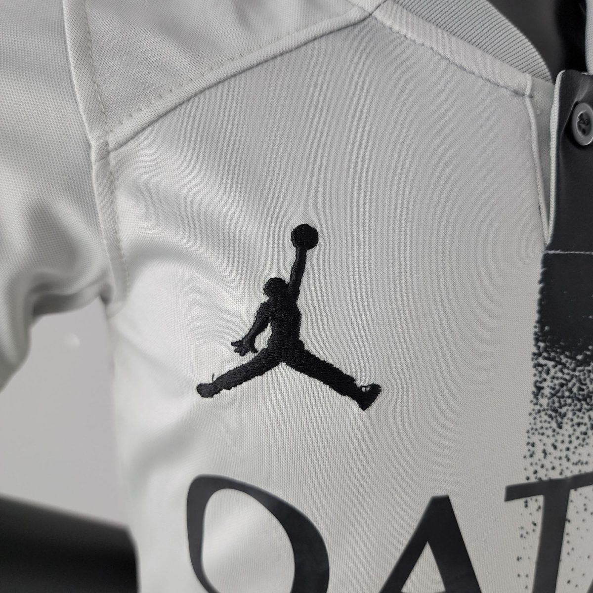 Close-up of white fabric with a black Jumpman silhouette logo on a sports jersey.