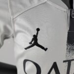 Close-up of white fabric with a black Jumpman silhouette logo on a sports jersey.