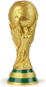 Gold World Cup trophy with green and gold base, raised hands holding a globe symbolizing global football.