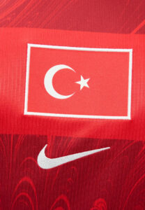 Red athletic jersey featuring a white-bordered red patch with a crescent and star (Turkish flag) and a white Nike swoosh nearby.