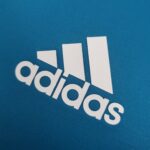 63861fee_8c11aae7-b3bd-4158-975b-48974b53fb11 | UAE SPORT STORE Partial view of a blue textured fabric with white letters spelling part of the word 'Google'.