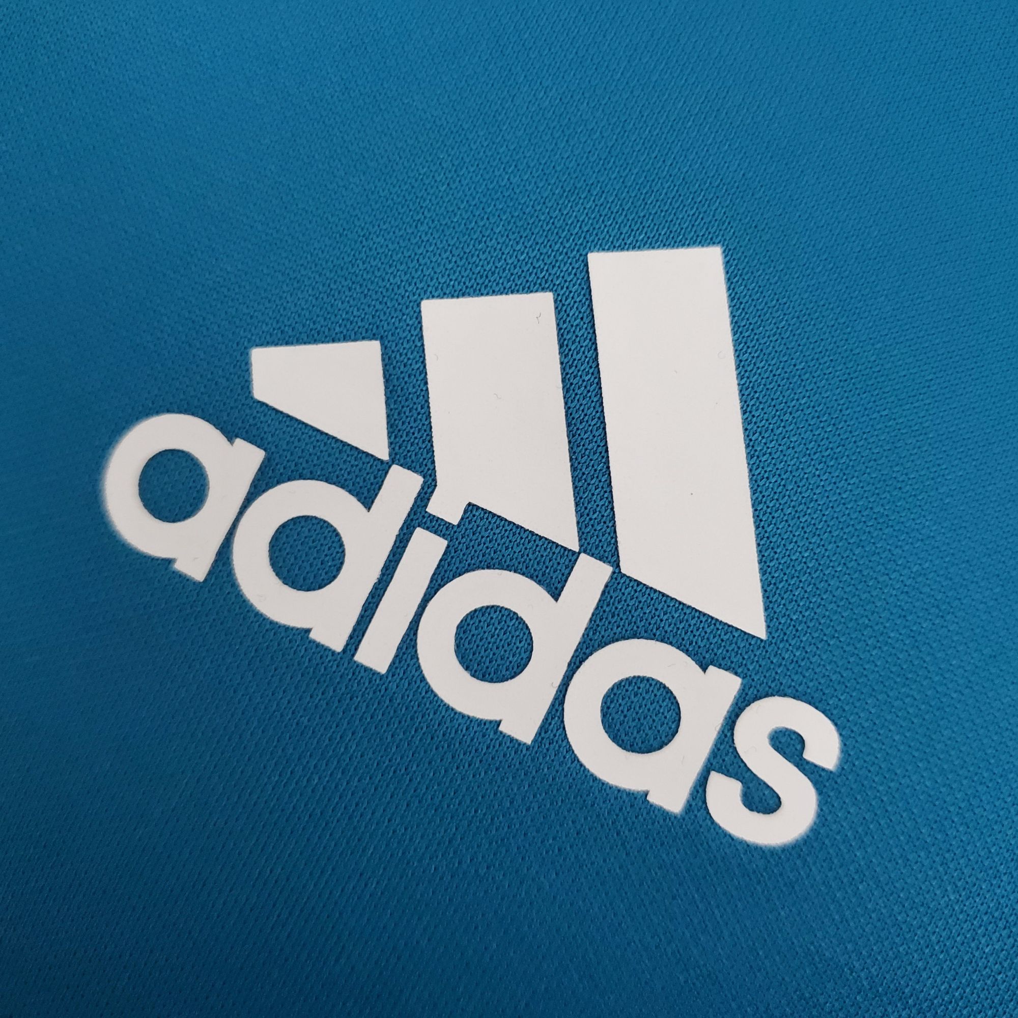 63861fee_8c11aae7-b3bd-4158-975b-48974b53fb11 | UAE SPORT STORE Partial view of a blue textured fabric with white letters spelling part of the word 'Google'.