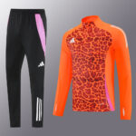 Two-piece athletic outfit: black joggers with pink side panels and white stripes, paired with an orange leopard-print long-sleeve top with purple side panels.