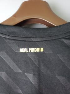 Dark gray suit jacket on a brown hanger, with Real Madrid text visible on the inside collar area.