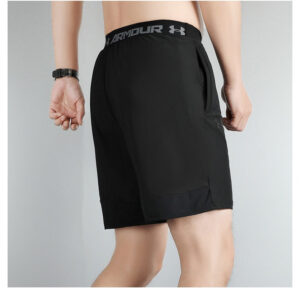 6424bf76 | UAE SPORT STORE Back view of a person wearing black Under Armour athletic shorts with a branded waistband and a side pocket.