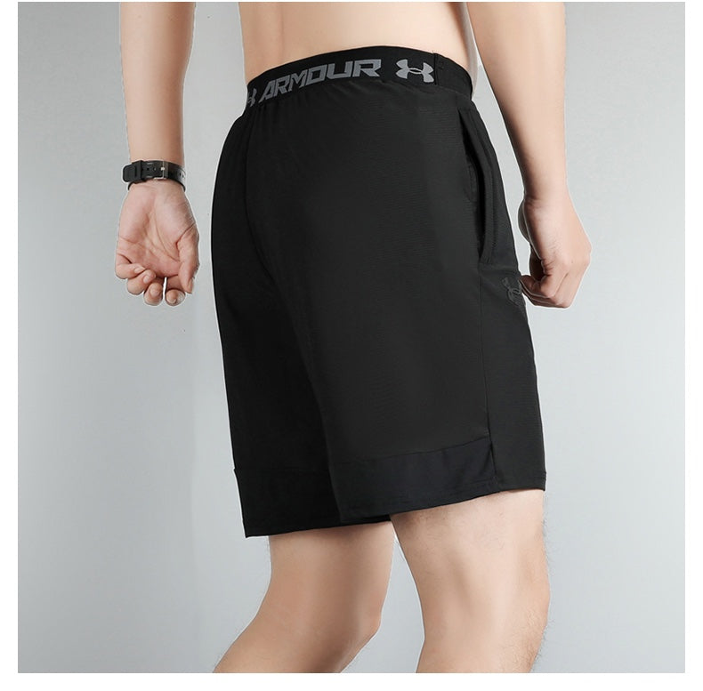6424bf76 | UAE SPORT STORE Back view of a person wearing black Under Armour athletic shorts with a branded waistband and a side pocket.