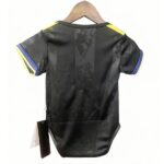 Back view of a black athletic jersey with yellow shoulder stripes and blue sleeve trim, hanging on a wooden hanger.