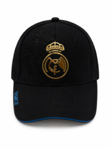 Black baseball cap with a gold Real Madrid crest embroidered on the front and blue trim along the bill.