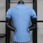 Back view of a light blue athletic jersey on a black display mannequin against a metal grid wall.