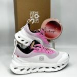 Loewe branded chunky sneakers in pink, white, and lavender with a sculpted white sole, displayed beside a Loewe box.