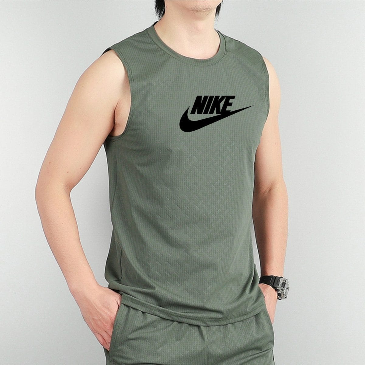Person wearing a green sleeveless Nike shirt with a large black **Nike** swoosh logo on the chest, cropped mid-torso.