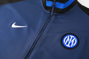 694ac0fe | UAE SPORT STORE Close-up of a navy blue zip-up jacket with a white Nike swoosh and an Inter Milan badge on the chest.
