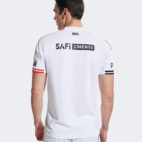 Man in a white athletic jersey seen from behind, with 'SAFi CIMENTO' logo on the back and red/black sleeve stripes.