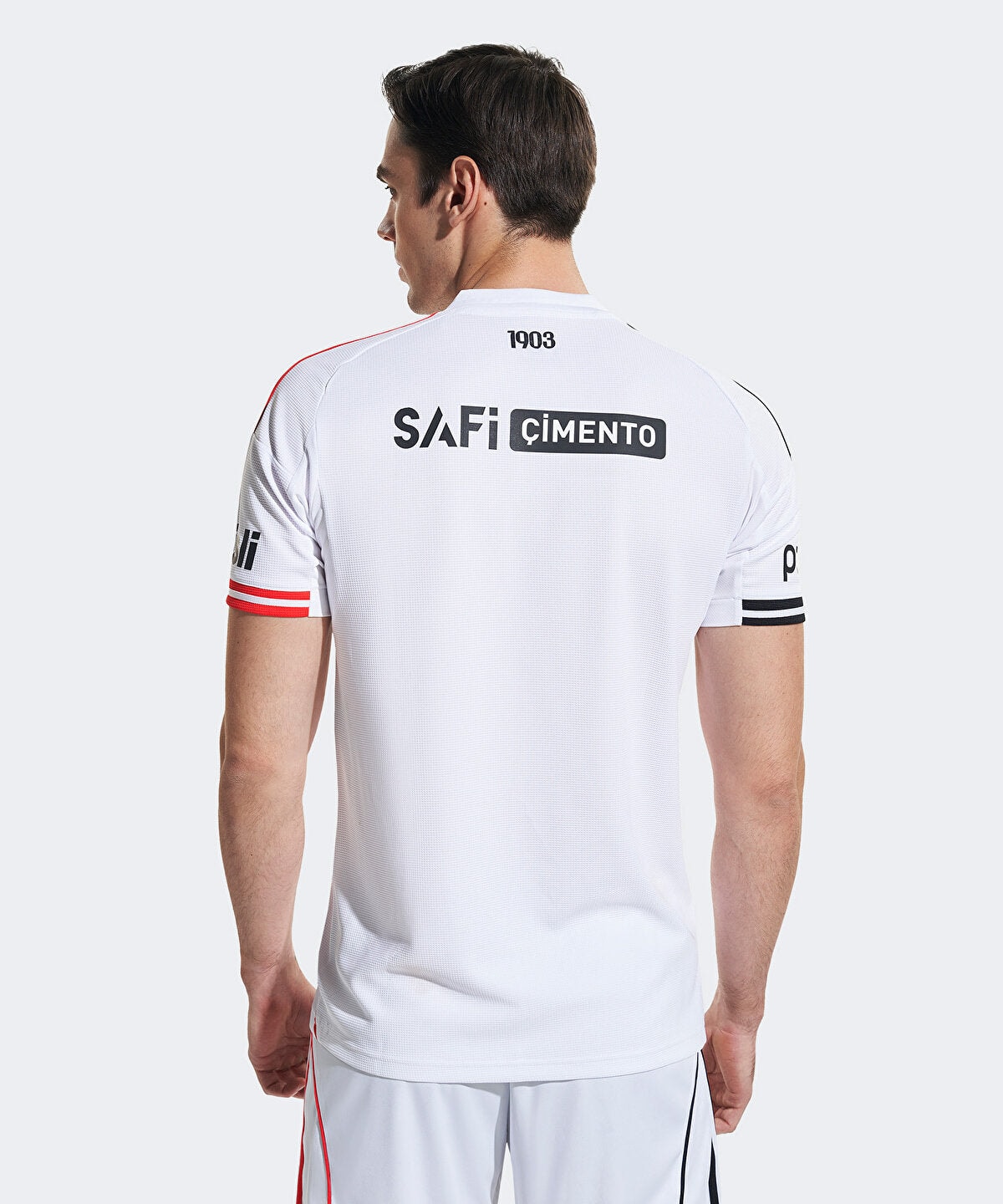 6KS4E0100001-01_6 | UAE SPORT STORE Man in a white athletic jersey seen from behind, with 'SAFi CIMENTO' logo on the back and red/black sleeve stripes.