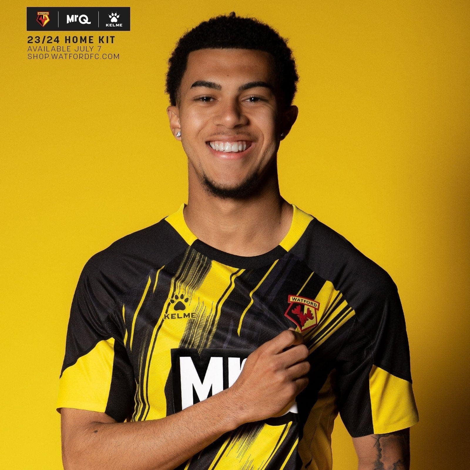 6WmOCCbG0Je56b1_825ce918-a2a4-414d-b7c1-2d0f74b5b86e | UAE SPORT STORE Smiling man in a black and yellow Watford FC jersey against a bright yellow background, crest visible on the chest.