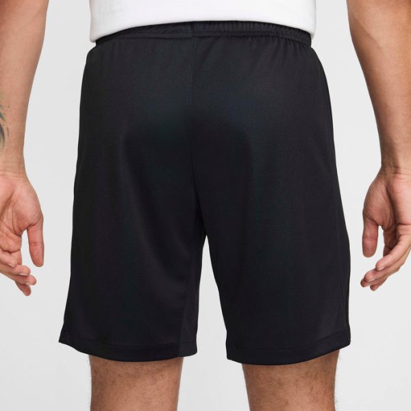 Back view of a person wearing black athletic shorts with an elastic waistband.