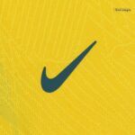 6ad93499-b7ed-4fc8-acac-86cc8cd1f003 | UAE SPORT STORE Dark teal Nike swoosh logo on a textured yellow fabric background.