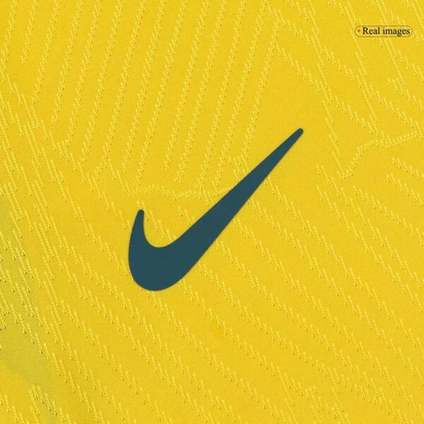 Dark teal Nike swoosh logo on a textured yellow fabric background.