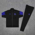 Black tracksuit set with royal blue accents: full-zip jacket with matching pants and a club emblem on the chest and thigh area