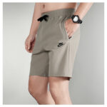 6bd021cb | UAE SPORT STORE Gray Nike athletic shorts with a black drawstring, logo on the left thigh, and hands in pockets, model wearing a watch.