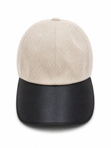 Beige mesh baseball cap with a black leather bill, front view showcasing two-tone design