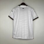 White polo shirt on a hanger, small black bat emblem on the back near the collar, and a Puma logo on the left sleeve.