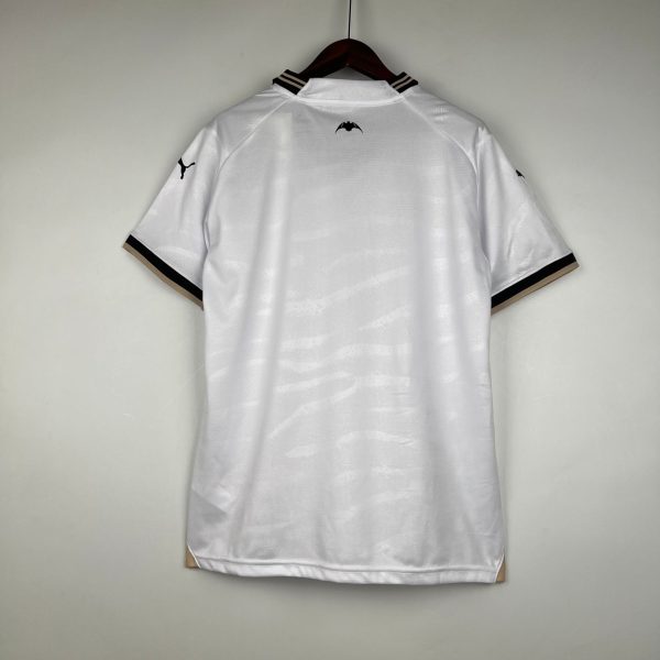 White polo shirt on a hanger, small black bat emblem on the back near the collar, and a Puma logo on the left sleeve.