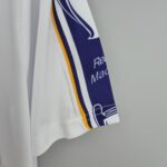 6dba39ab_0d68dd9d-8176-47c0-8c93-25dae2d88d5f | UAE SPORT STORE Close-up of white fabric with a blue-and-white striped ribbon and orange edge.