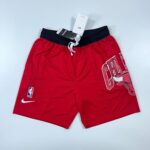 Red basketball shorts with a black waistband, white drawstring, featuring an NBA logo patch and a large Bulls graphic on the right leg.