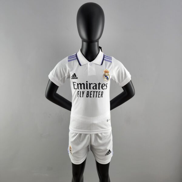 Mannequin wearing a Real Madrid white soccer jersey with purple shoulder stripes, standing against a gray background.