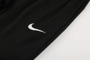 6ef83acc | UAE SPORT STORE Close-up of black fabric with a white Nike swoosh logo visible on the left side of the image.