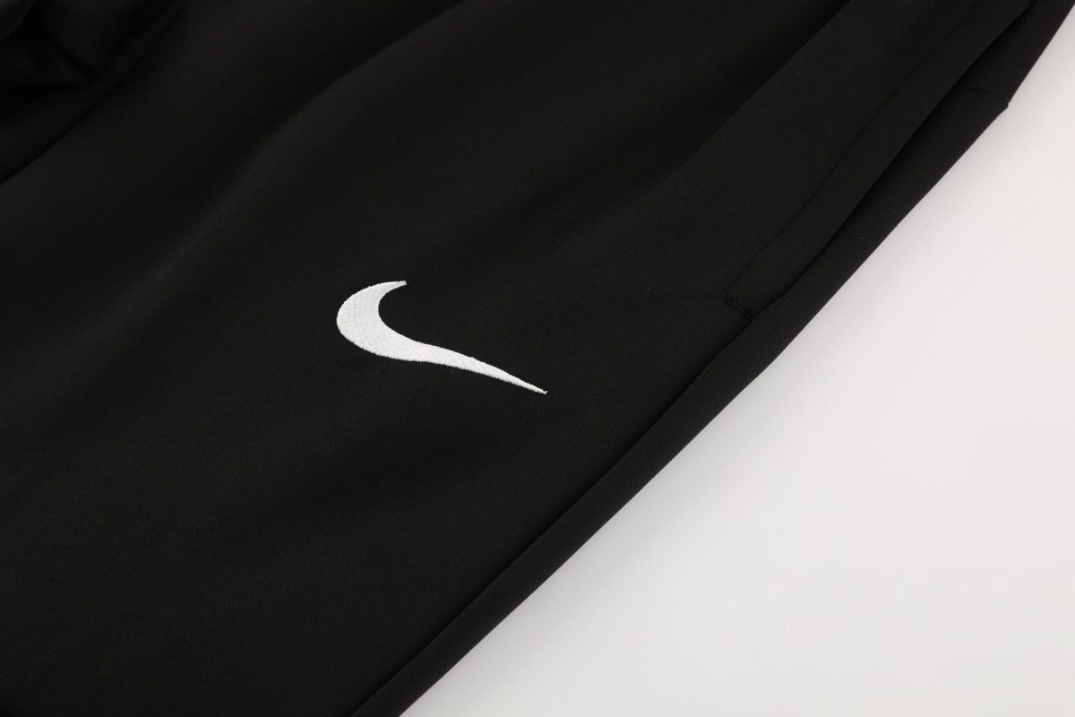 Close-up of black fabric with a white Nike swoosh logo visible on the left side of the image.