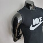 Glossy metallic mannequin bust wearing a black Nike sleeveless shirt with a large white logo menacingly visible.