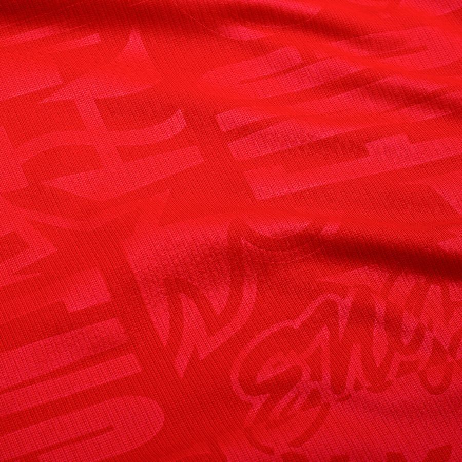 6f212de613e8 | UAE SPORT STORE Close-up of bright red fabric with a subtle printed pattern and visible knit texture.