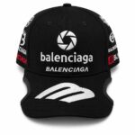 Black Balenciaga cap with white embroidered logos on the front and sides and a curved brim.