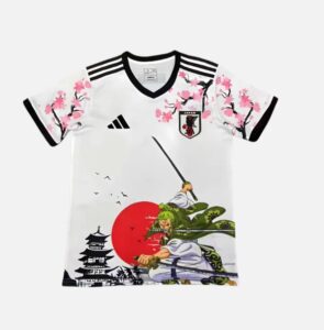 White Japan soccer jersey with black trim and cherry blossom artwork, featuring a large red sun and two samurai-like figures in action.