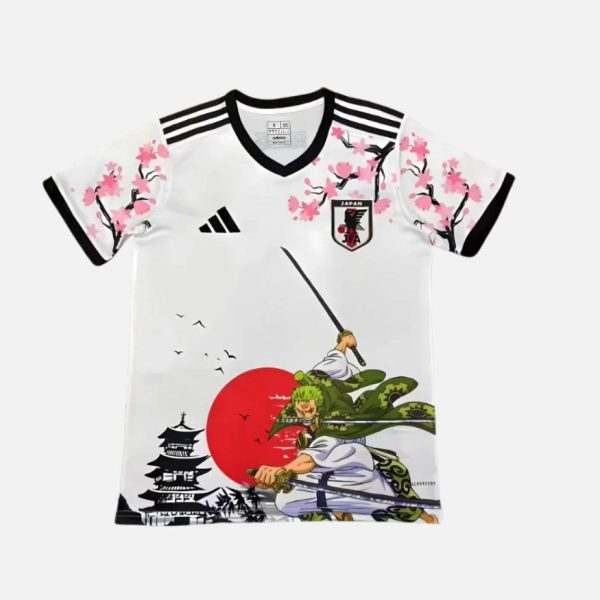 White Japan soccer jersey with black trim and cherry blossom artwork, featuring a large red sun and two samurai-like figures in action.
