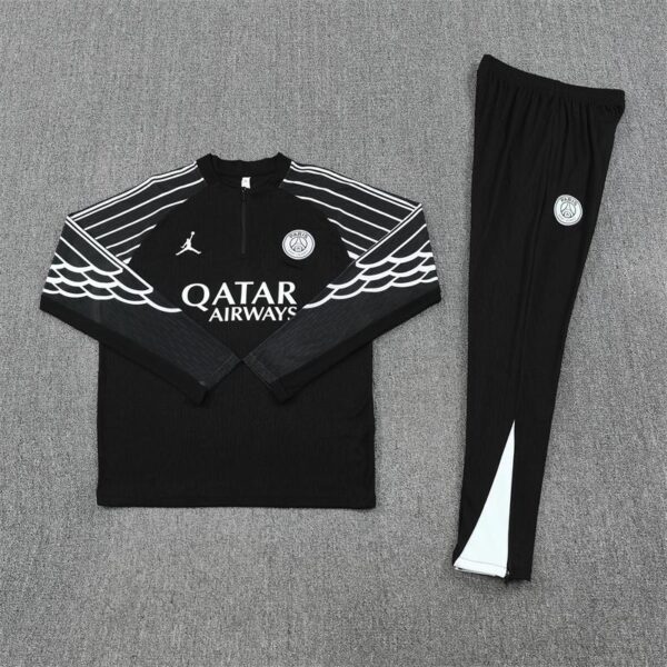 Black athletic tracksuit with white wing stripe design across the chest and sleeves, features Paris Saint-Germain crest and Qatar Airways logo on the jacket.