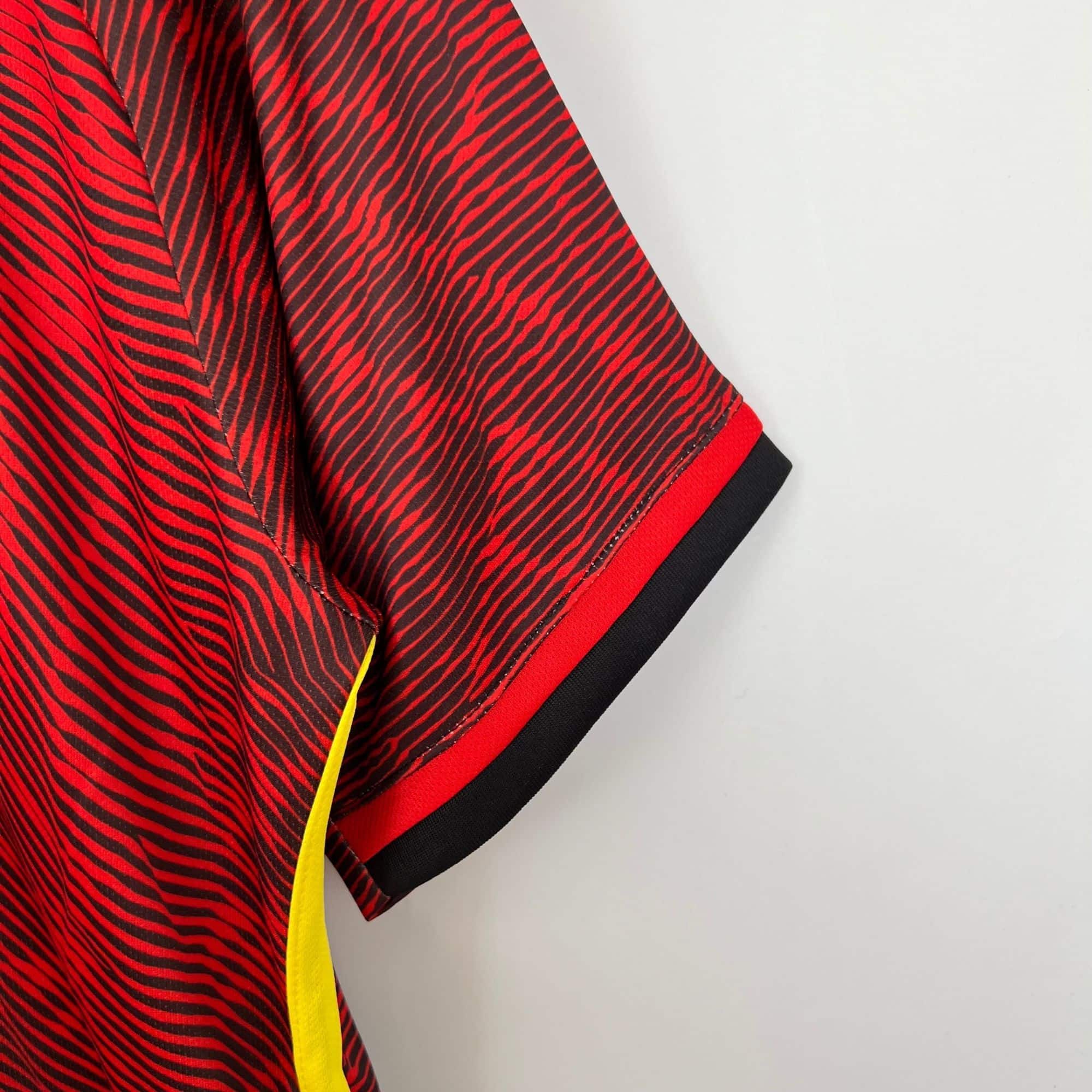 6f4b9f3b_1514c01b-43e0-47f9-82cf-64102204f99a | UAE SPORT STORE Close-up of red and black zebra-striped fabric with a bright yellow edge trimming the material.