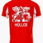 Red football/soccer jersey back with a white collage graphic and the name MÜLLER, number 25, on a red shirt.