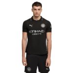 Young man in a black Manchester City football jersey with sponsor Etihad Airways and club crest, facing camera.