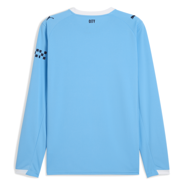 Back view of a light blue long-sleeve sports jersey with a white collar edge, 'CITY' text at the neck, and dark logos on the shoulders; left forearm features a dark checker pattern.
