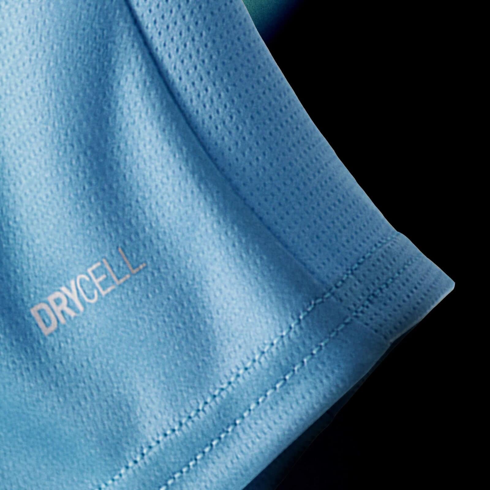 701237129001_pp_05_mcfc | UAE SPORT STORE Close-up of light blue perforated fabric with visible stitching and a partial